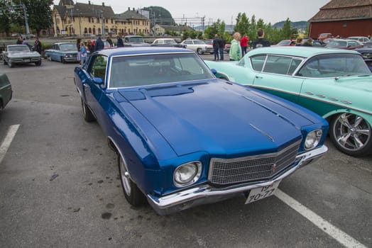 The image is shot at a fish-market in Halden, Norway where there every Wednesday during the summer months are held classic American car show.