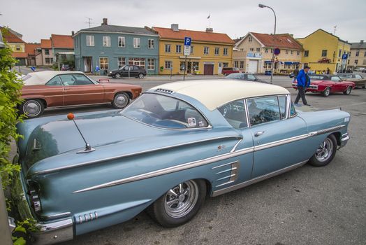 The image is shot at a fish-market in Halden, Norway where there every Wednesday during the summer months are held classic American car show.