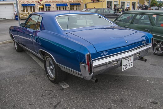 The image is shot at a fish-market in Halden, Norway where there every Wednesday during the summer months are held classic American car show.