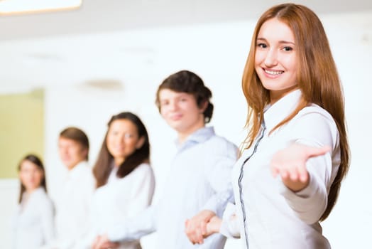 group of people holding hands, woman holds out her hand, the concept of teamwork