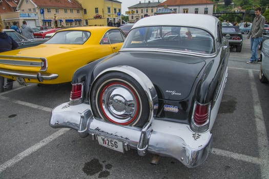 The image is shot at a fish-market in Halden, Norway where there every Wednesday during the summer months are held classic American car show.