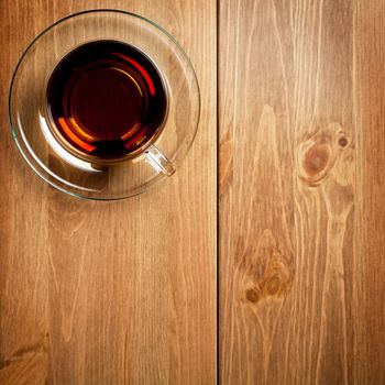 Tea in glass cup on wooden table background. Top view