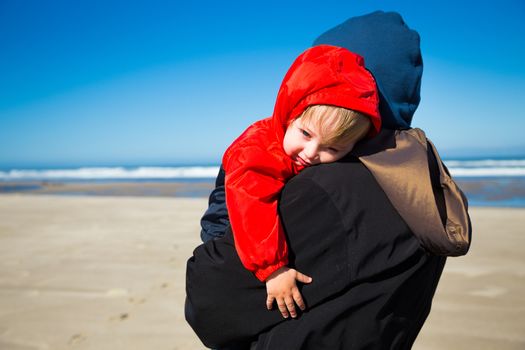 A very sleep kid rests in the arms of his grandmother after playing at the beach in the Pacific northwest.