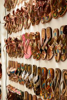 Some differente shoes on a wall in an arabian market