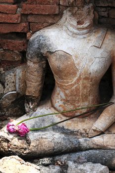 Statue of a deity with lotus flowers in the Historical Park of Sukhothai, Thailand
