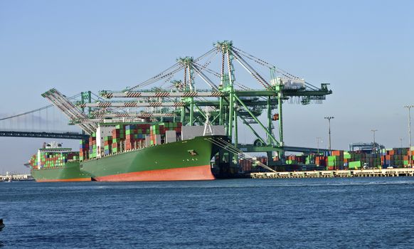 Cargo ships loading and unloading cargo in Long Beach industrial seaport.