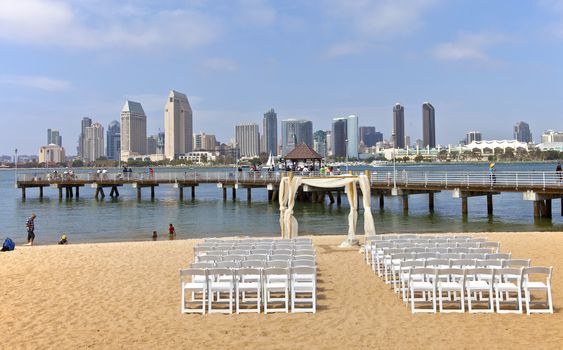 San Diego - June 1st  2013: A view of The San Diego skyline and a wedding preparation setup on a beach on Coronado island June 1st, 2013 in Coronado Island California. 
