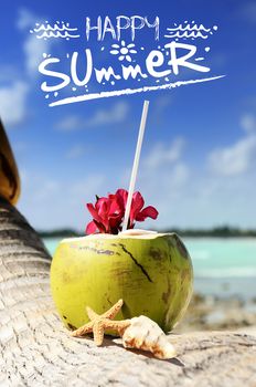 Coconut with drinking straw on a palm tree at the sea