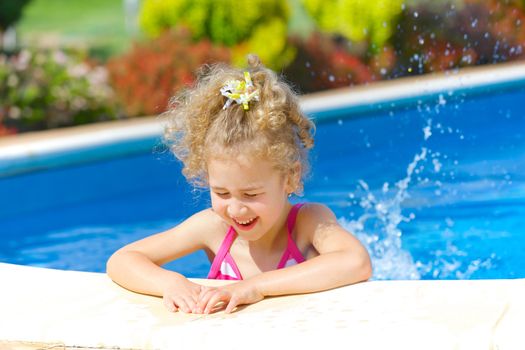 Pretty little girl in swimming pool outdoors