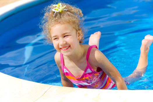 Pretty little girl in swimming pool outdoors