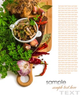 Marinated mushrooms in a cup on the background of a cutting board and spices