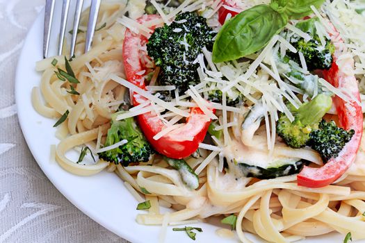 Pasta Primavera made with fresh broccoli, asparagus, red bell pepper and zucchini and served with freshly grated parmesan cheese. 