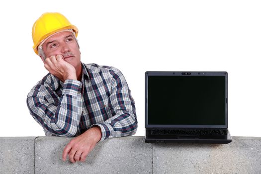 Builder with a laptop showing a blank screen