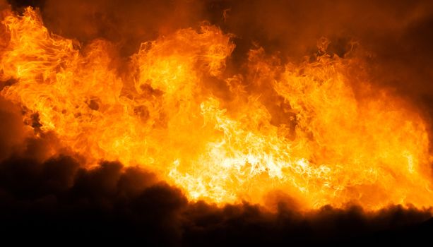 Arson or nature disaster - burning fire flame on wooden house roof