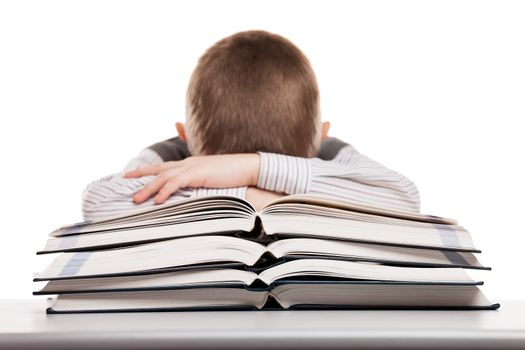 Tired child boy sleeping on education reading books at school desk