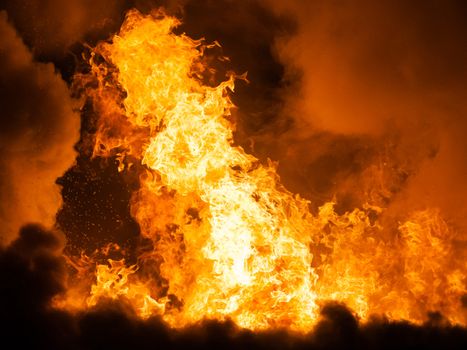 Arson or nature disaster - burning fire flame on wooden house roof