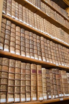 Shelves in antique library full of very old books