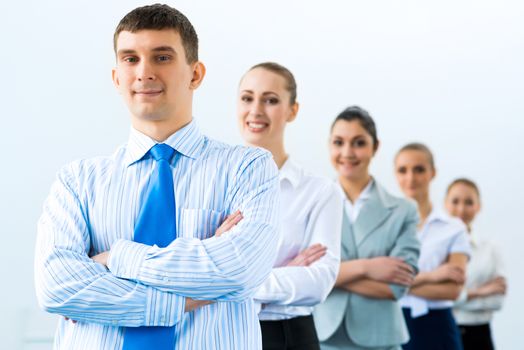 group of business people standing in a row, smiling and crossing his arms