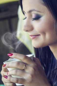 beautiful brunnette drinking coffee in a restaurant outdoor