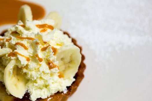 A fresh banana cream pie ready to be served to guests. Toppings of honey