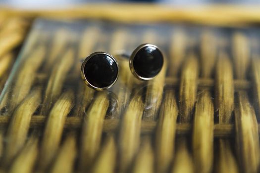 Close up of a couple cufflinks on a wodden table