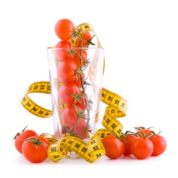 Small tomatoes in a glass and tailor tape isolated on white