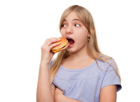 Girl eating a hamburger isolated on white.