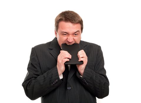 Rage against a tablet -  Angry businessman biting his tablet.