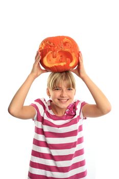 Smiling girl puts a halloween pumpkin onto her head isolated on white
