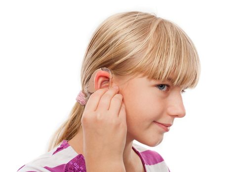 Teen girl wearing a hearing aid. Studio shot-isolated on white background.