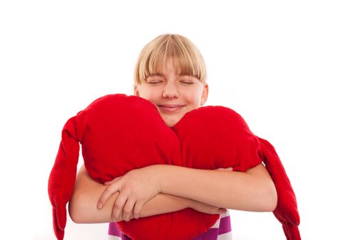 Portrait of a nice girl embracing a red heart plush, isolated on white background
