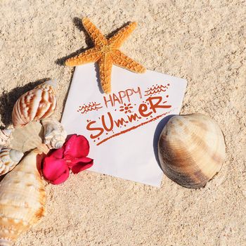 blank paper on white sand beach with starfish and shells like summer vacation background