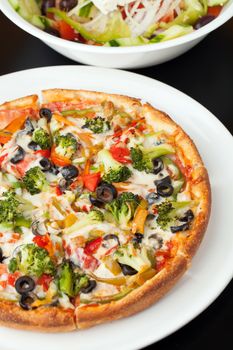 A fresh medium size specialty pizza with extra toppings hot and fresh out of the oven. 