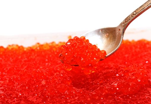 Red salted caviar with spoon on a white background