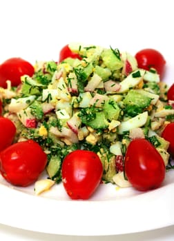 Salad with potatoes, eggs, cherry tomatoes, closeup on white background