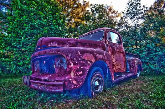 abandoned rusty vehicle on the farm lawn