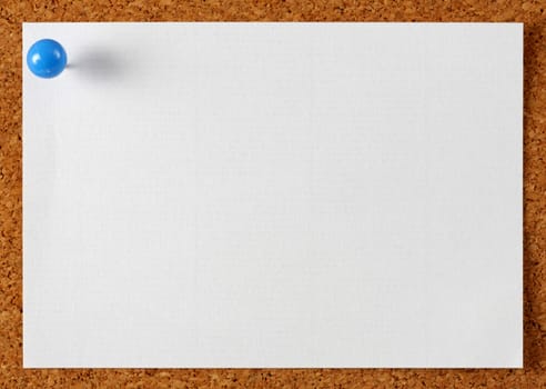 Note memo paper with blue pin on cork board