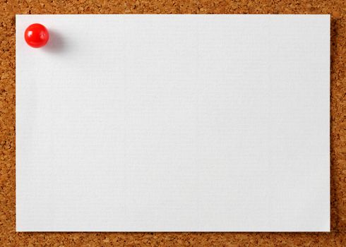 Note memo paper with red pin on cork board