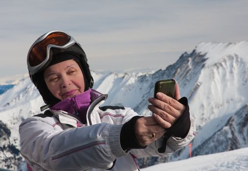 A woman photographs the skier himself smartphone