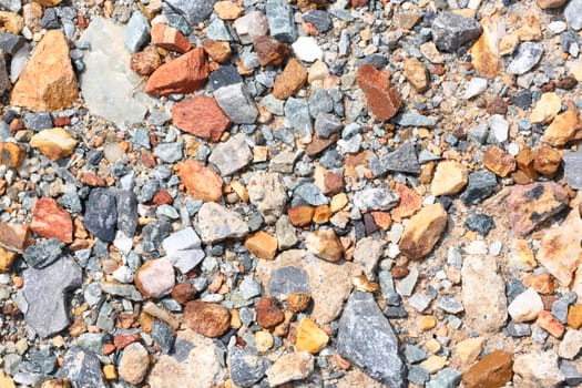 Multicolored crushed stone in bright sunlight day