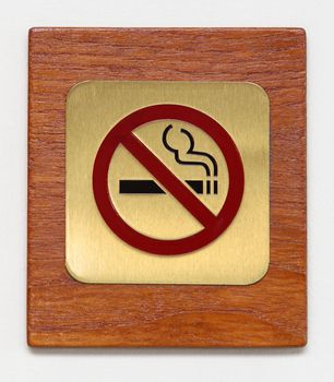 brass no smoking sign on plywood isolated on white