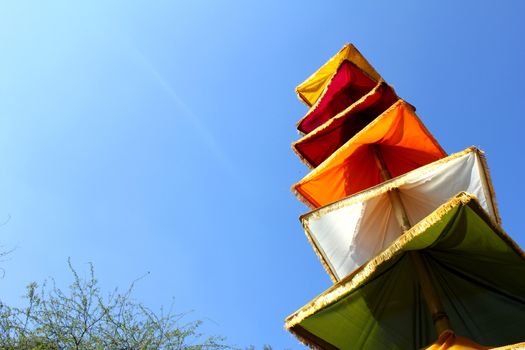 tricolor cloths on sticks under blue sky