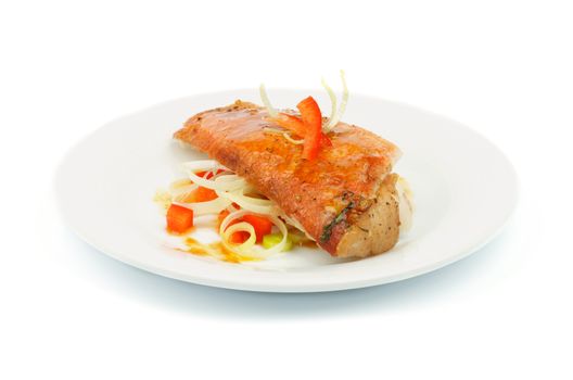 Delicious Roasted Red Snapper Fish Garnished with Red Bell Pepper and Leek Saute with Sauce on Plate isolated on white background