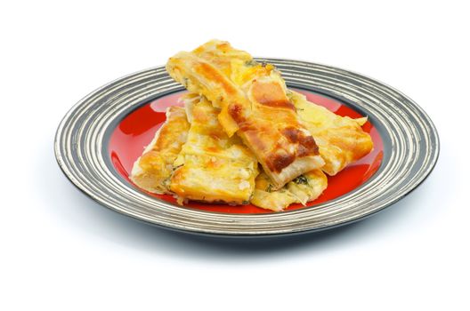 Slices of Cheese and Greens Puff Pastry Pie on Red Striped Plate isolated on white background