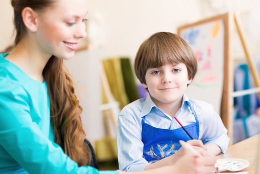 teacher deals with a boy, a drawing lesson