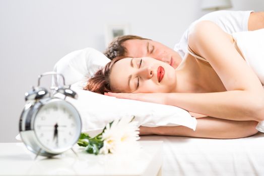 young beautiful woman sleeping on the bed with her husband