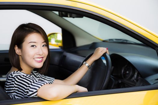 Lady driver in her yellow car looking at camera