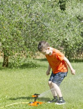 Happy Child Playing with Water in the Garden.