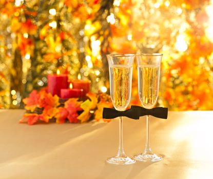 Champagne glasses with conceptual same sex decoration for gay men in front of autumn deco