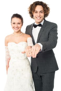 Happy bride and groom displaying their wedding rings